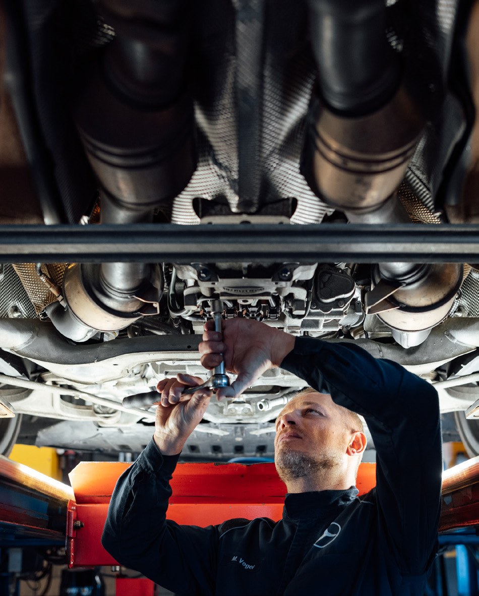 Mechaniker unter einem Mercedes-Benz auf der Hebebühne
