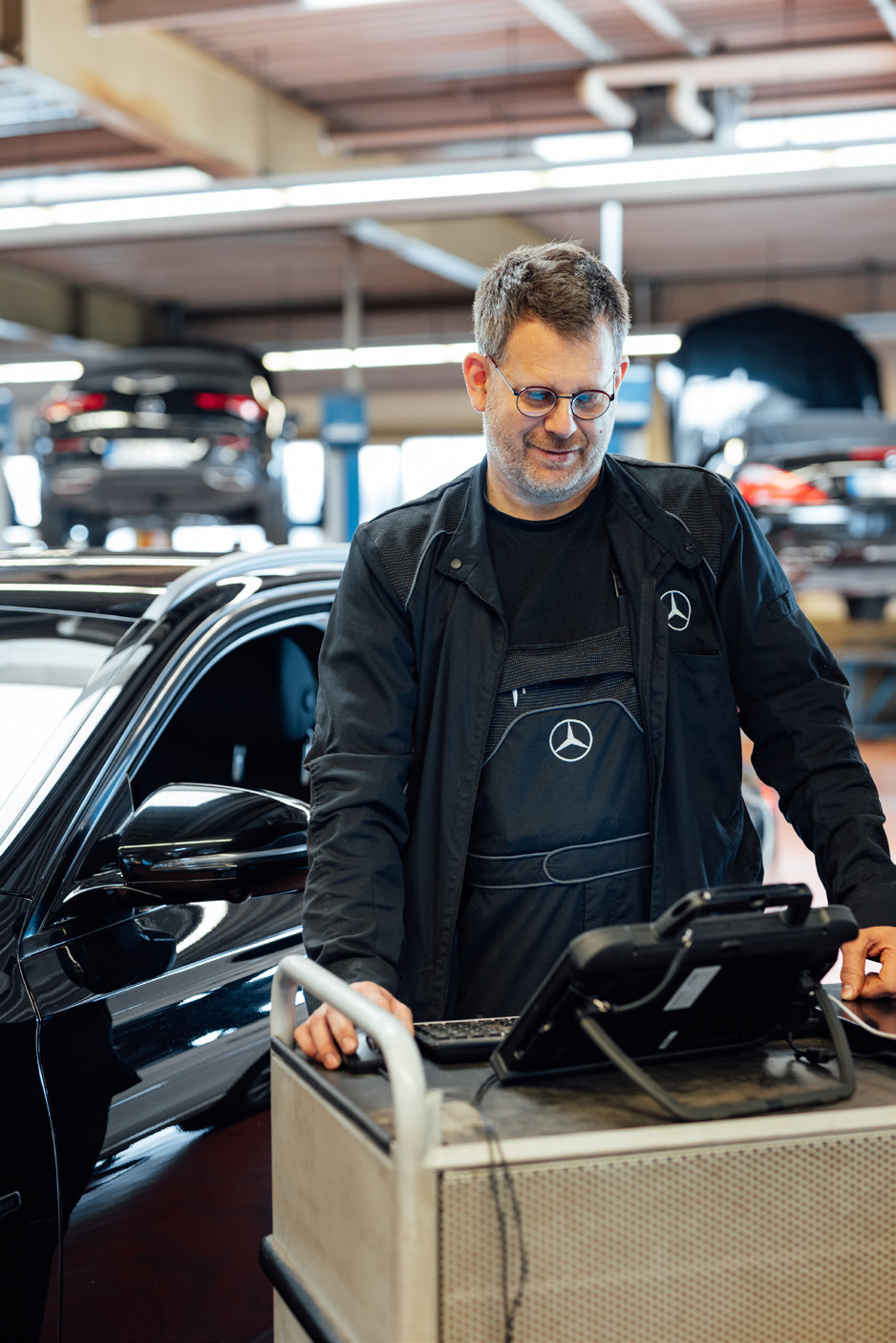 Serviceberater mit Diagnosegerät am Fahrzeug